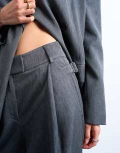 Model wearing Tonic pleated suit trouser with side buckle in grey