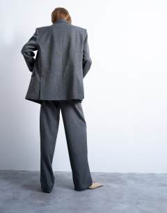 Model wearing Tonic pleated suit trouser with side buckle in grey