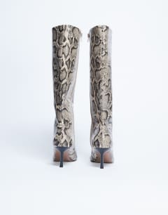Model wearing Tori knee high point toe boot in snake