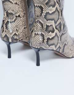 Model wearing Tori knee high point toe boot in snake
