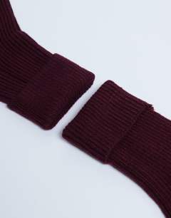 Model wearing Tot ribbed cosy boot sock in burgundy