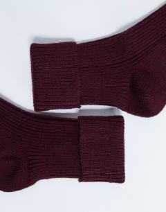 Model wearing Tot ribbed cosy boot sock in burgundy