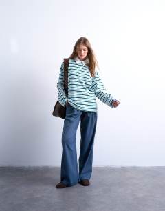 Model wearing Towelling stripe polo in blue and green