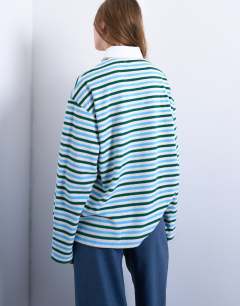 Model wearing Towelling stripe polo in blue and green