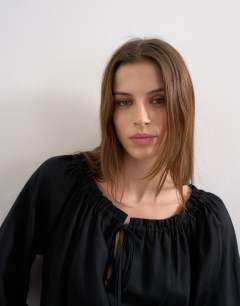 Model wearing Trapeze linen tie front blouse in black