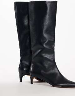 Model wearing Troy kitten heel knee high boot in black