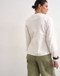 Model wearing Tuck waist long sleeve tee in ivory
