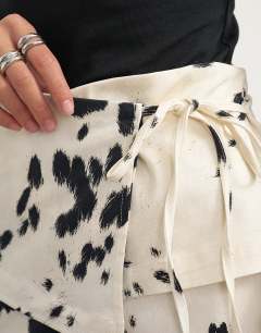 Model wearing Twill wrap tie detail maxi skirt in cow print