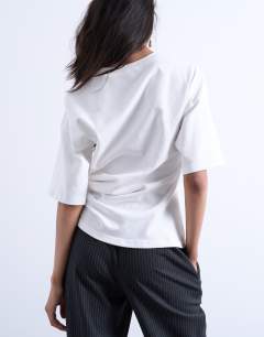 Model wearing Twisted detail t-shirt in ivory