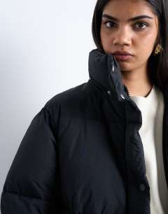 Model wearing Ultimate longline funnel neck puffer jacket in black