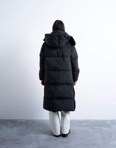 Model wearing Ultimate longline funnel neck puffer jacket in black