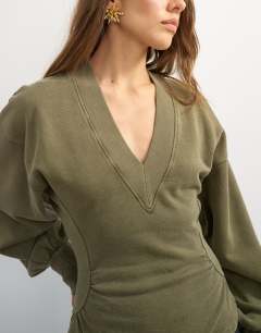 Model wearing V-neck cinch waist sweat in khaki