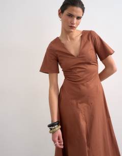 Model wearing V neck heavy seamed midi dress in rust