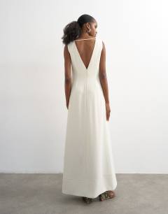 Model wearing V neck low armhole clean maxi dress with deep hem in off white