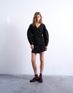 Model wearing V neck ovoid sleeve top in black