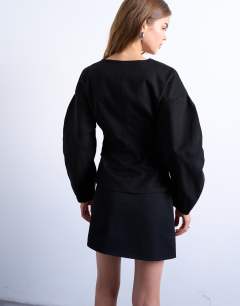 Model wearing V neck ovoid sleeve top in black