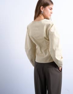 Model wearing V neck ovoid sleeve top in cream