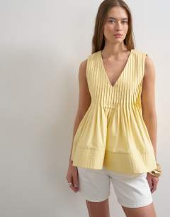 Model wearing V neck pintuck detail a line top in lemon yellow
