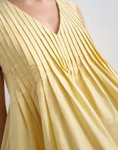 Model wearing V neck pintuck detail a line top in lemon yellow