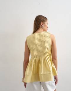 Model wearing V neck pintuck detail a line top in lemon yellow