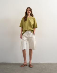 Model wearing V-neck premium interlock tee in khaki