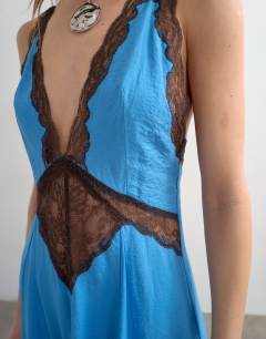 Model wearing V neck satin slip dress with chocolate brown contrast lace inserts in cornflower blue