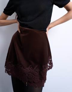 Model wearing Velvet asymmetric mini skirt with lace trim in chocolate