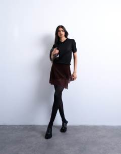 Model wearing Velvet asymmetric mini skirt with lace trim in chocolate