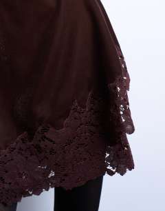 Model wearing Velvet asymmetric mini skirt with lace trim in chocolate