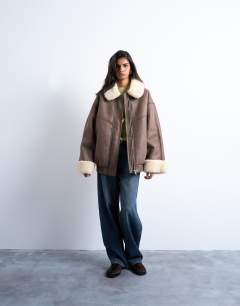 Model wearing Vintage washed faux shearling super oversized bomber jacket in brown