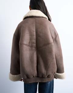 Model wearing Vintage washed faux shearling super oversized bomber jacket in brown