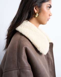 Model wearing Vintage washed faux shearling super oversized bomber jacket in brown