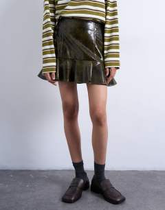 Model wearing Vinyl peplum hem mini skirt in green