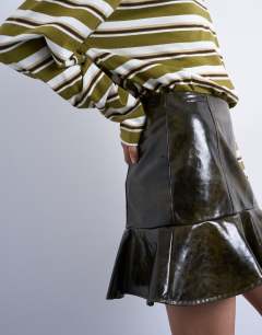 Model wearing Vinyl peplum hem mini skirt in green