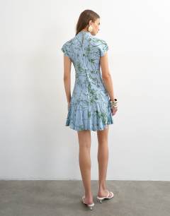 Model wearing Viscose grown on sleeve dress in blue and green sketchy floral