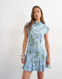 Model wearing Viscose grown on sleeve dress in blue and green sketchy floral