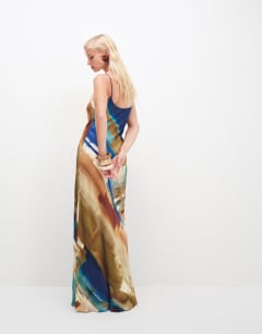 Model wearing Viscose satin low scoop flood length maxi slip dress in abstract ochre print