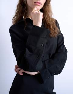 Model wearing Waisted micro mini shirt dress in black cupro