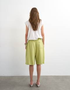 Model wearing Washed long line tie detail shorts in washed lime