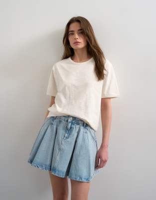 Topshop - Weiter Mini-Faltenrock aus Denim in Bleach-Waschung-Blau