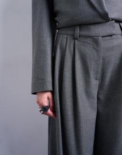 Model wearing Wide pleat trousers in grey