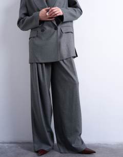 Model wearing Wide pleat trousers in grey