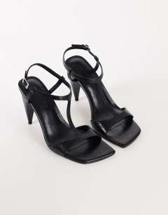 Model wearing Willow T bar banana heel sandal in black