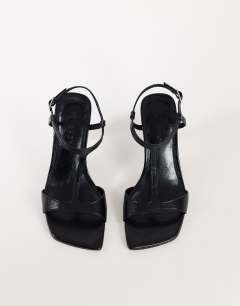 Model wearing Willow T bar banana heel sandal in black