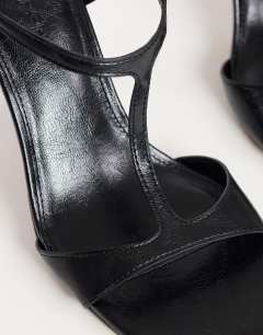 Model wearing Willow T bar banana heel sandal in black