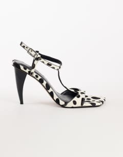 Model wearing Willow T bar banana heel sandal in dalmatian hair on real leather