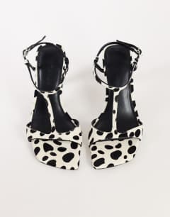 Model wearing Willow T bar banana heel sandal in dalmatian hair on real leather