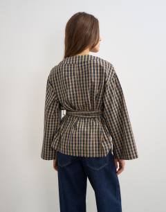 Model wearing Wrap tie detail top in check print