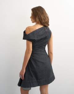 Model wearing X Cara denim asymmetric off shoulder mini dress in washed black