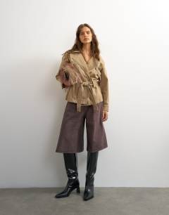 Model wearing X Cara denim cropped trench jacket in washed beige